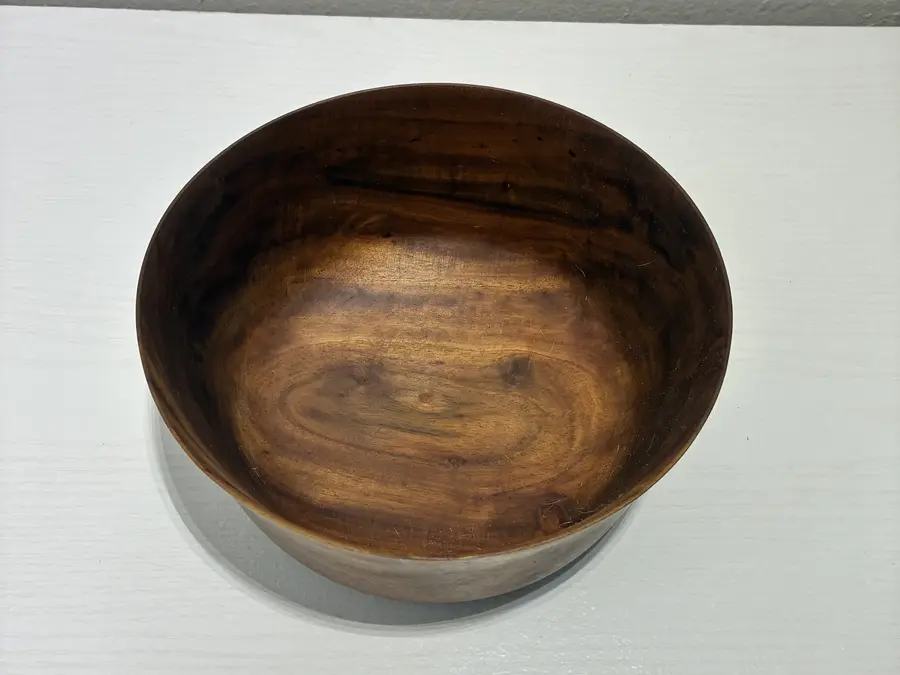 Looking down into the flared bowl, its oiled grain swirling dark and gold