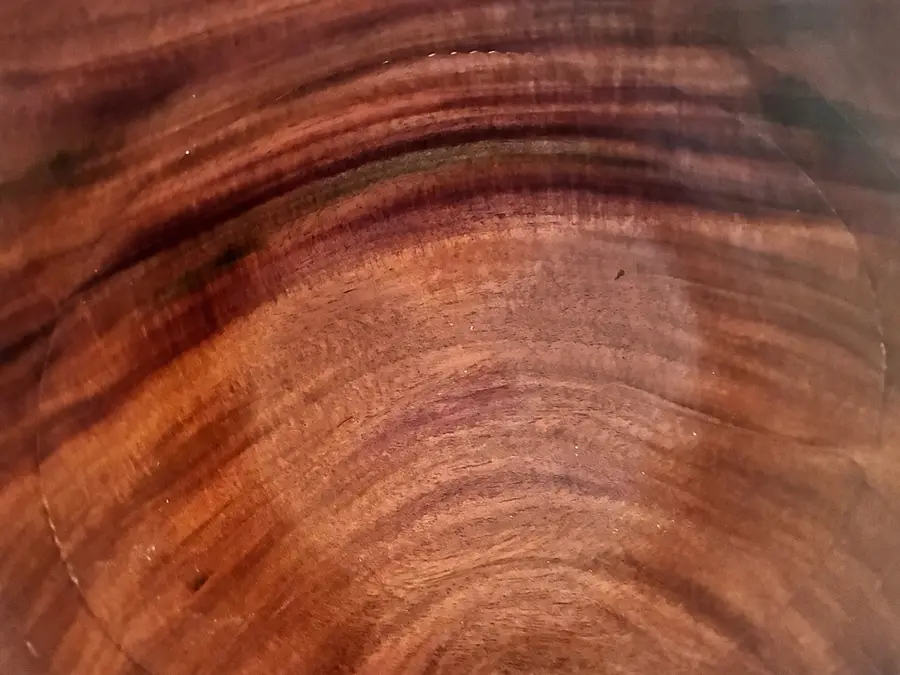 Close in on the inside of one of Kaleb’s mango bowls: red-brown grain, darker streaks and a ripple of figure