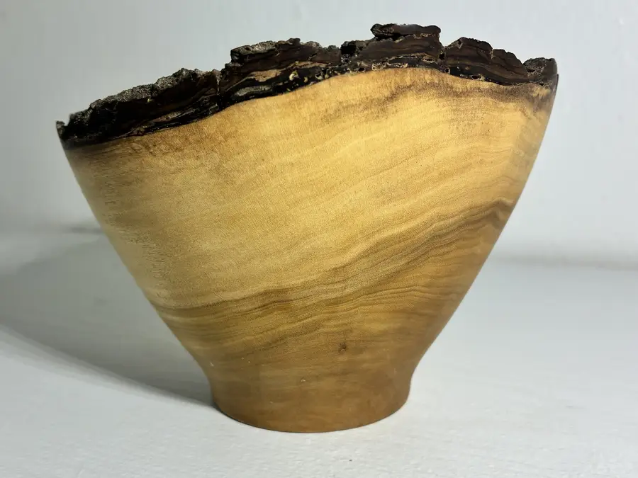 The naio bowl close up from the side: golden grain sweeping up to the bark at its rim