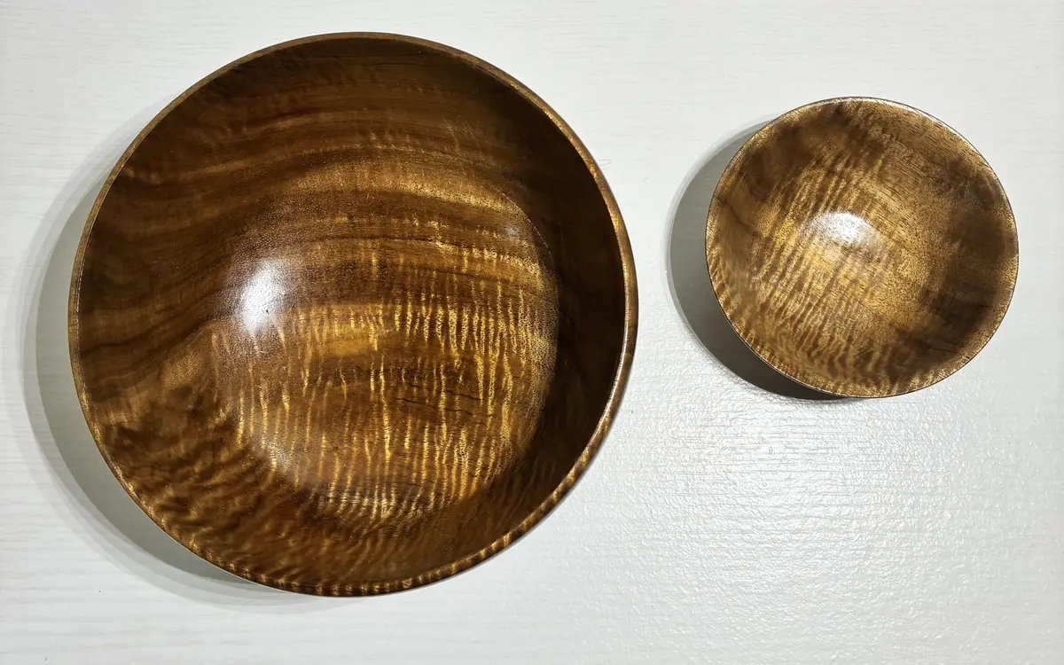 The curly koa pair from above, the curl catching the light across both bowls