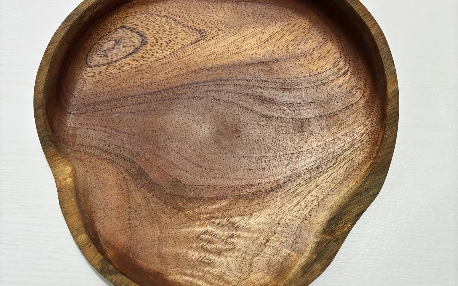 The free-form platter from above: a knot near one edge and a ripple of curl along the other