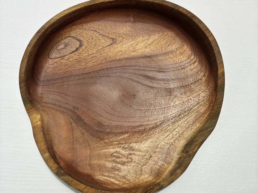 The free-form platter from above: a knot near one edge and a ripple of curl along the other
