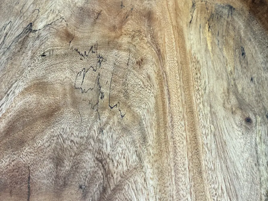 Close in on the spalted mango bowl: black zone lines wandering through pale grain