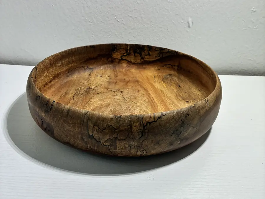 Kaleb’s spalted mango bowl, low and wide, with black spalting lines across its side