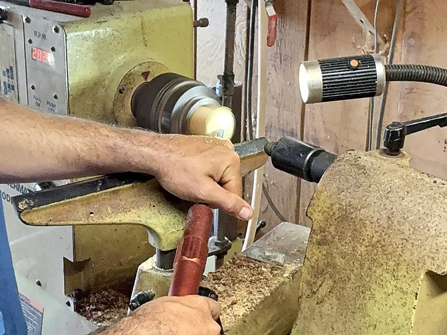 Kaleb’s hands at the lathe, the tool on the rest and the wood spinning in the chuck